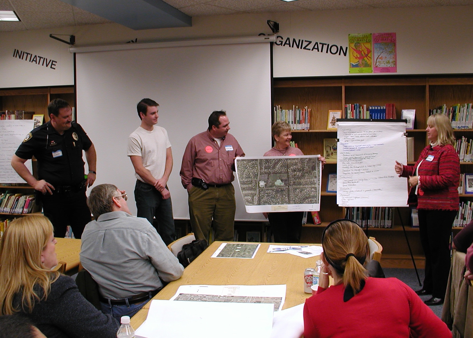 group of adults looking at maps around a conference table.