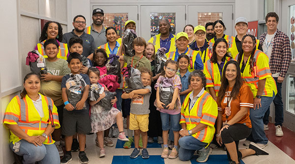 gathering of kids and crossing guards inside of a school hallway